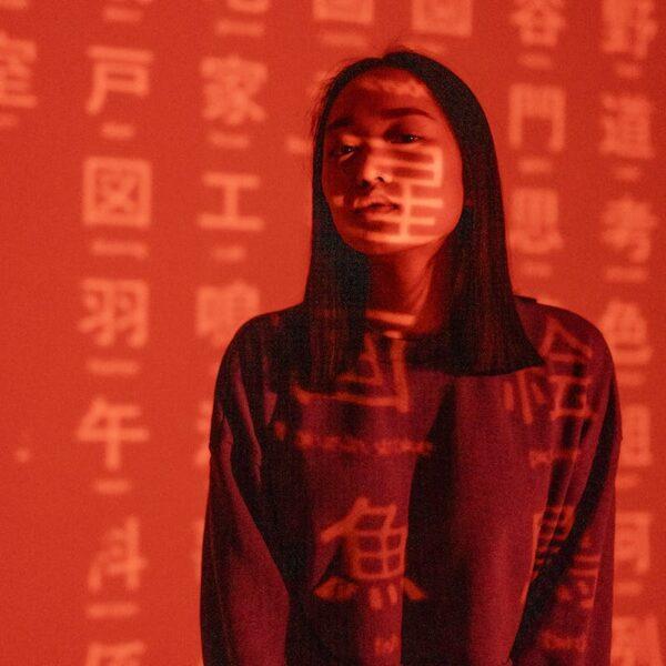 Chinese Characters overlaying a Woman in Long Sleeves