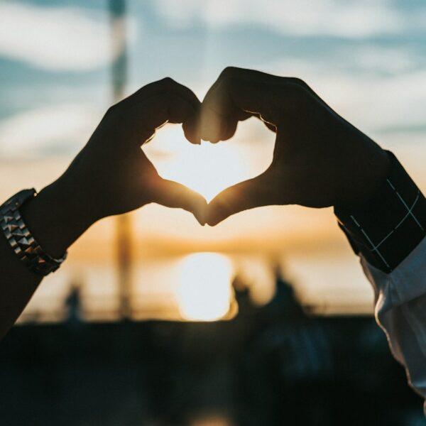 person forming heart with their hands